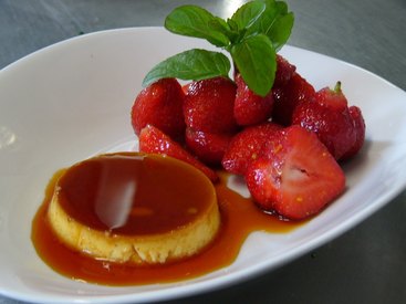 Hausgemachte Crème Caramel mit frischen Erdbeeren
